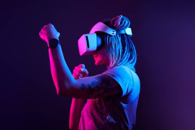 Kadın sanal gerçeklik kulaklığı kullanıyor. Neon Light Stüdyo Portresi.
