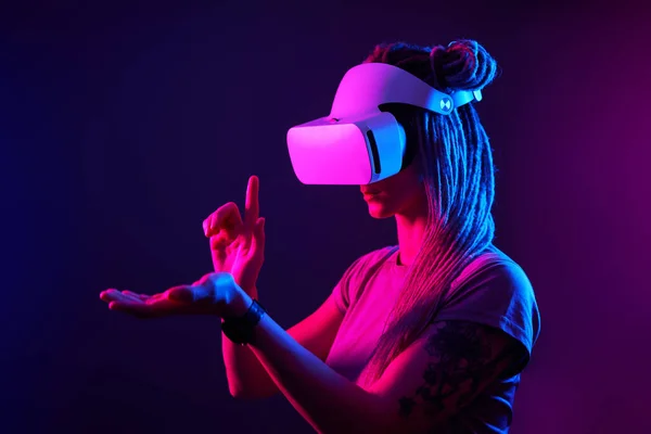 Donna sta usando cuffie realtà virtuale. Neon luce studio ritratto. — Foto Stock