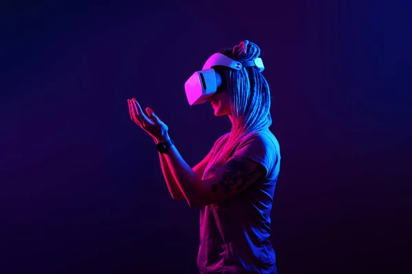 Vrouw gebruikt virtual reality headset. Neon licht studio portret. — Stockfoto
