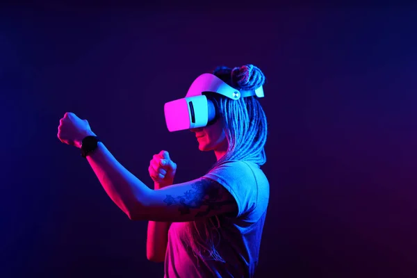 Femeia folosește căști de realitate virtuală. Neon light studio portret . — Fotografie, imagine de stoc