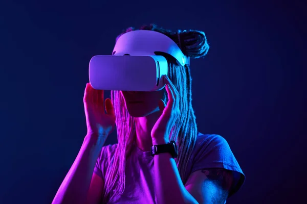 Donna sta usando cuffie realtà virtuale. Neon luce studio ritratto. — Foto Stock