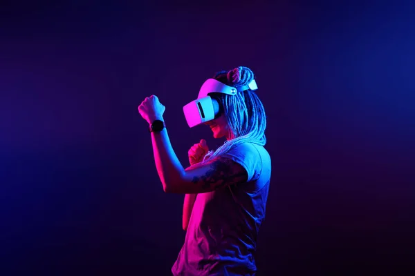 Η γυναίκα χρησιμοποιεί ακουστικά εικονικής πραγματικότητας. Προσωπογραφία στούντιο νέον φως. — Φωτογραφία Αρχείου