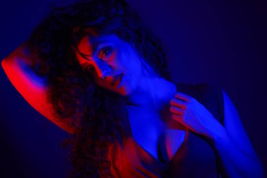 Stüdyoda kameraya bakan genç bir kadın, yakın plan, kırmızı ve mavi fotoğraf.