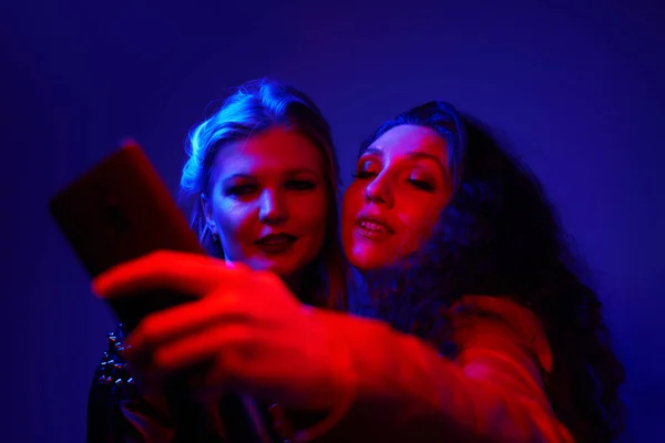 Dos Mujeres Toman Selfie Estudio Foto Azul Roja — Foto de Stock