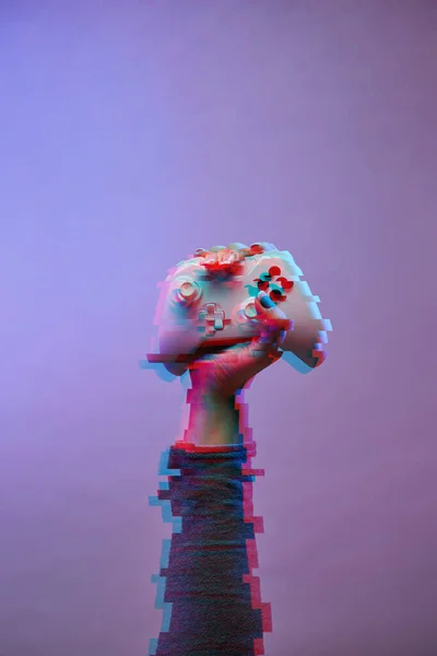 Hand med vit gamepad på violett bakgrund. Bild med glitch effekt. — Stockfoto