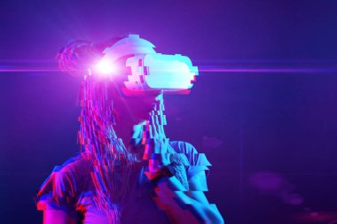 Woman is using virtual reality headset. Neon light studio portrait. Image with glitch effect.