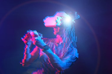 Woman is using virtual reality headset. Neon light studio portrait. Image with glitch effect.