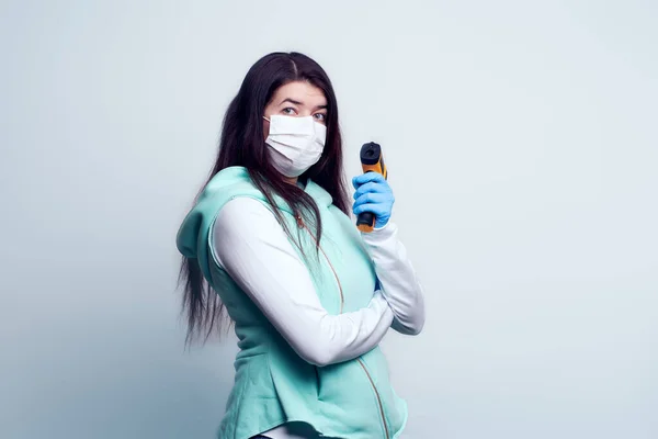 Портрет молодої жінки в медичній масці з безконтактним інфрачервоним термометром в руці . — стокове фото