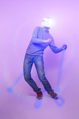 Sanal gerçeklik kulaklığı kullanarak dağda kayak yapan bir adam..