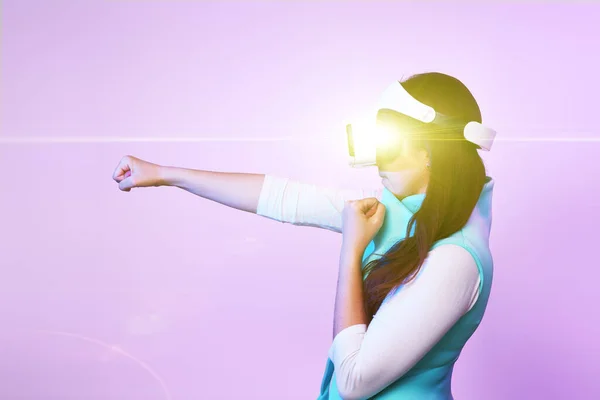 Mulher está usando fone de ouvido realidade virtual, jogando jogo e lutando . — Fotografia de Stock