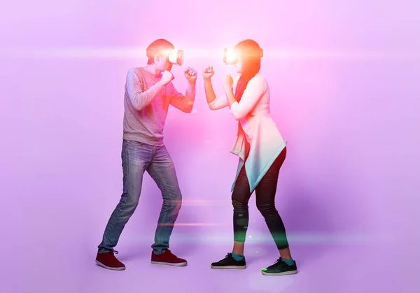 Ζευγάρι με ακουστικά εικονικής πραγματικότητας παίζουν παιχνίδι και μάχες. — Φωτογραφία Αρχείου
