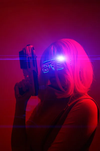 Meisje met blaster in de futuristische strijd. Concept virtual reality, cyber game. — Stockfoto