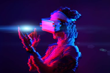 Woman is using virtual reality headset. Neon light studio portrait. Image with glitch effect.