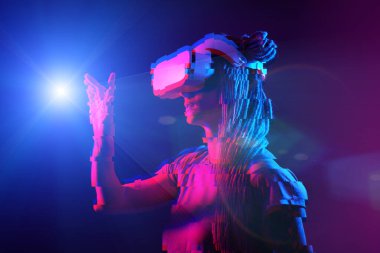 Woman is using virtual reality headset. Neon light studio portrait. Image with glitch effect.
