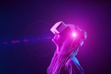 Kadın sanal gerçeklik kulaklığı kullanıyor. Neon Light Stüdyo Portresi.