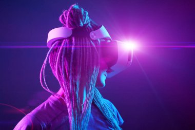 Kadın sanal gerçeklik kulaklığı kullanıyor. Neon Light Stüdyo Portresi.