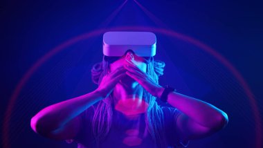Kadın sanal gerçeklik kulaklığı kullanıyor. Neon Light Stüdyo Portresi.