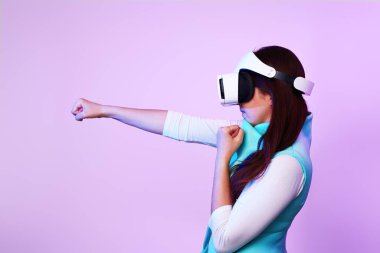 Kadın sanal gerçeklik kulaklığı kullanıyor, oyun oynuyor ve kavga ediyor..