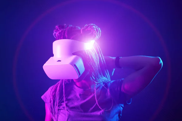 La mujer está usando auriculares de realidad virtual. Retrato de estudio de luz de neón. — Foto de Stock