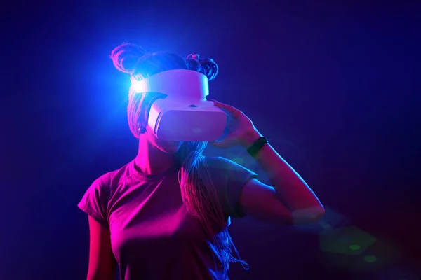 Donna sta usando cuffie realtà virtuale. Neon luce studio ritratto. — Foto Stock