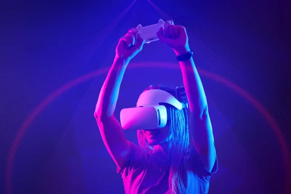 Donna sta usando cuffie realtà virtuale. Neon luce studio ritratto. — Foto Stock