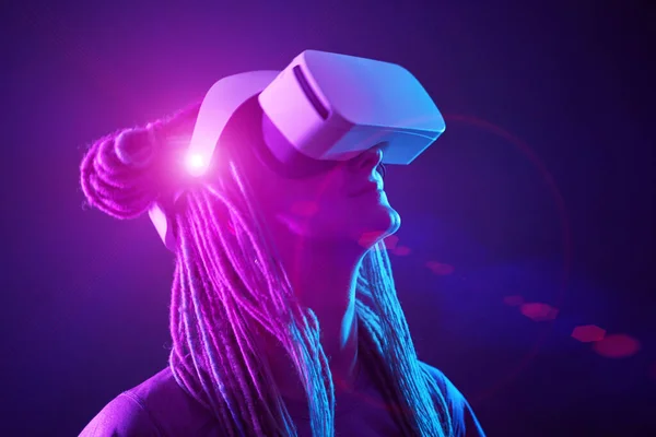 Vrouw gebruikt virtual reality headset. Neon licht studio portret. — Stockfoto