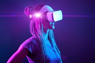 Kadın sanal gerçeklik kulaklığı kullanıyor. Neon Light Stüdyo Portresi.