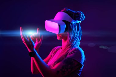 Kadın sanal gerçeklik kulaklığı kullanıyor. Neon Light Stüdyo Portresi.