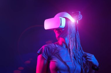 Kadın sanal gerçeklik kulaklığı kullanıyor. Neon Light Stüdyo Portresi.