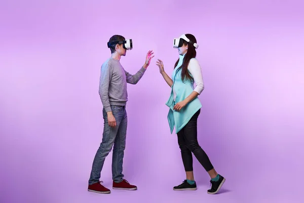 Pareja enamorada comunicarse usando un auricular de realidad virtual . — Foto de Stock