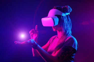Kadın sanal gerçeklik kulaklığı kullanıyor. Neon Light Stüdyo Portresi.