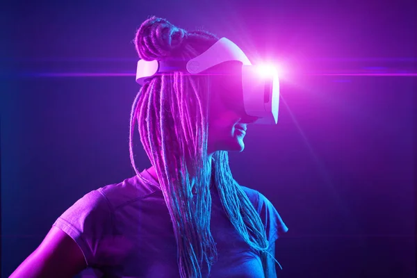 Kvinna använder virtuell verklighet headset. Neon ljus studio porträtt. — Stockfoto