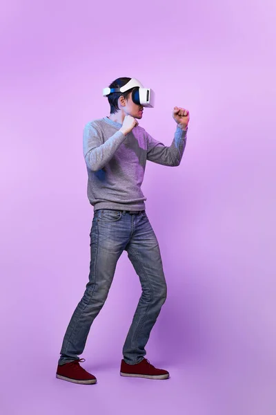 Homem com fone de ouvido realidade virtual está jogando jogo e luta . — Fotografia de Stock