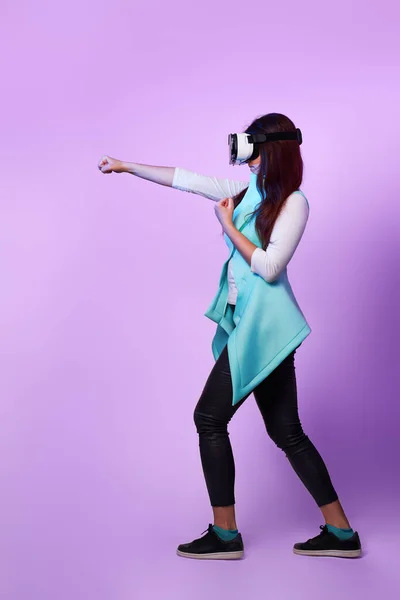 Mulher está usando fone de ouvido realidade virtual, jogando jogo e lutando . — Fotografia de Stock