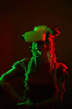 Woman is using virtual reality headset. Neon light studio portrait. Image with glitch effect.