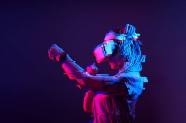 Woman is using virtual reality headset. Neon light studio portrait. Image with glitch effect.