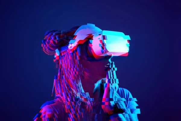 Woman is using virtual reality headset. Neon light studio portrait. Image with glitch effect. — Zdjęcie stockowe