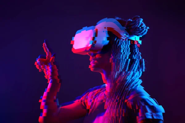Woman is using virtual reality headset. Neon light studio portrait. Image with glitch effect. — Stockfoto