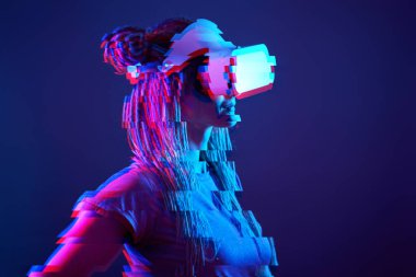 Woman is using virtual reality headset. Neon light studio portrait. Image with glitch effect.