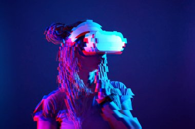 Woman is using virtual reality headset. Neon light studio portrait. Image with glitch effect.