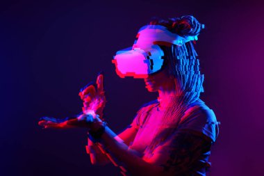 Woman is using virtual reality headset. Neon light studio portrait. Image with glitch effect.