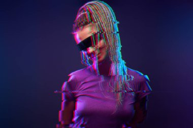 Güneş gözlüklü genç kız neon ışıkta kameraya bakıyor. Hata efektli resim.