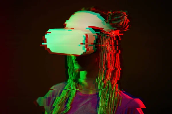 Женщина использует гарнитуру виртуальной реальности. Неоновый легкий студийный портрет. Изображение с эффектом сбоя . — стоковое фото