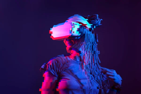 Woman is using virtual reality headset. Neon light studio portrait. Image with glitch effect. — Stockfoto