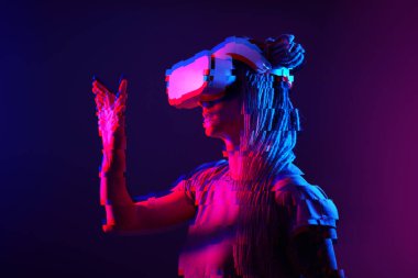 Woman is using virtual reality headset. Neon light studio portrait. Image with glitch effect.