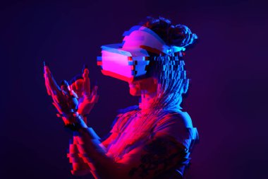 Woman is using virtual reality headset. Neon light studio portrait. Image with glitch effect.