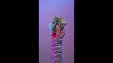 Mor arka planda el ele tutuşma banknotları. Bomerang videosu.