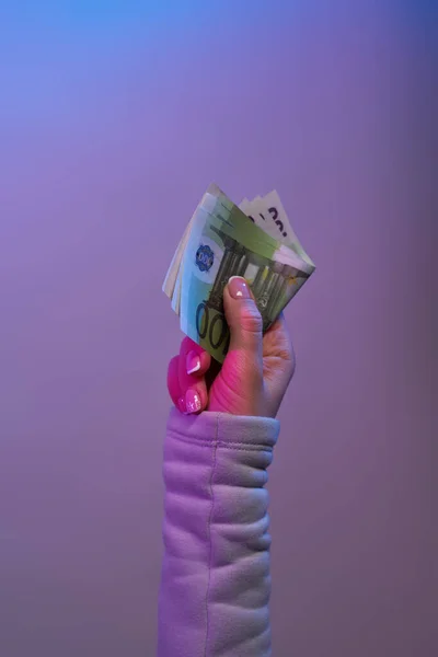 Billetes de mano sobre fondo violeta . — Foto de Stock