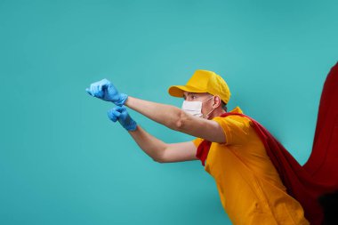 Kurye süper kahraman maskesi ve koruyucu yüz maskesi takıyor..