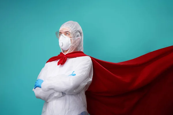 El médico está usando PPE - traje, guantes y mascarilla quirúrgica en capa de superhéroe . —  Fotos de Stock